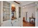 Charming bar area with custom glass cabinetry, shelving, and granite countertop at 7340 Golf Pointe Cir, Sarasota, FL 34243