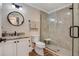 Bathroom featuring a granite countertop, a glass enclosed shower and modern lighting at 7340 Golf Pointe Cir, Sarasota, FL 34243