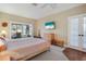 Bright bedroom with sliding glass doors to a patio, ceiling fan, wood floors and light colored walls provide a serene retreat at 7340 Golf Pointe Cir, Sarasota, FL 34243
