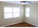 Bedroom with hardwood floors, ceiling fan, and natural light from windows with plantation shutters at 7340 Golf Pointe Cir, Sarasota, FL 34243