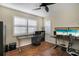 Bedroom area with wood floors, ceiling fan, plantation shutters and built-in work areas at 7340 Golf Pointe Cir, Sarasota, FL 34243