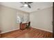 Bedroom with wood look floors, large window, and ceiling fan at 7340 Golf Pointe Cir, Sarasota, FL 34243