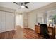 Bedroom area with wood floors, ceiling fan, natural light, and built-in work area at 7340 Golf Pointe Cir, Sarasota, FL 34243