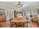 Spacious dining area with wood floors, elegant light fixture, and views of the living room at 7340 Golf Pointe Cir, Sarasota, FL 34243