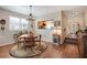 Dining area with wood table and floors, decorative lighting, and views into the kitchen at 7340 Golf Pointe Cir, Sarasota, FL 34243