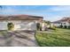 Well-manicured front yard with a two-car garage and tile roof at 7340 Golf Pointe Cir, Sarasota, FL 34243