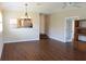 Open-concept living room features hardwood floors, modern lighting, and a view of the kitchen with stainless appliances at 7340 Golf Pointe Cir, Sarasota, FL 34243