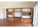 Open living room with wood floors and custom built-in shelves, ideal for storage and display, leading to a bright sunroom at 7340 Golf Pointe Cir, Sarasota, FL 34243