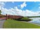 Scenic view of a red wooden bridge over the water, surrounded by green grass and clear blue skies at 7632 Plantation Cir, Bradenton, FL 34201