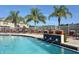 Relaxing community pool with lounge chairs, palm trees and water feature with a view of neighboring homes at 7632 Plantation Cir, Bradenton, FL 34201