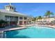 Bright community pool with lounge chairs, umbrellas, and community building in the background on a clear day at 7632 Plantation Cir, Bradenton, FL 34201