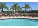Tranquil community pool area featuring a fountain, palm trees, and comfortable lounge chairs for residents at 7632 Plantation Cir, Bradenton, FL 34201