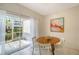 Cozy dining area with a round wooden table, white chairs, and sliding glass doors to the outside patio at 7632 Plantation Cir, Bradenton, FL 34201