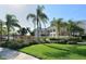 Well-maintained community building with lush landscaping, green grass, and palm trees on a bright day at 7632 Plantation Cir, Bradenton, FL 34201