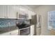 Well-lit kitchen featuring stainless steel appliances, granite countertops, and a stylish blue backsplash at 7632 Plantation Cir, Bradenton, FL 34201