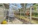 Relaxing screened patio with a table, chairs, and views of the surrounding landscaping at 7632 Plantation Cir, Bradenton, FL 34201
