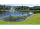 Scenic pond with a fountain and well-manicured landscaping, offering a serene view for residents at 7632 Plantation Cir, Bradenton, FL 34201