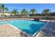Community pool with lounge chairs and palm trees at 7632 Plantation Cir, Bradenton, FL 34201