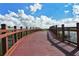 Charming wooden bridge with red railings offers a scenic view of the waterfront and lush surroundings at 7632 Plantation Cir, Bradenton, FL 34201