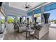 Covered outdoor lounge area with wicker furniture and tropical views at 8271 Redonda Loop, Lakewood Ranch, FL 34202