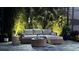 Cozy outdoor patio features comfortable wicker furniture, ambient lighting, and lush tropical foliage at 8271 Redonda Loop, Lakewood Ranch, FL 34202