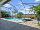 Screened-in pool with a jacuzzi, patio furniture, lush landscaping, and scenic lake views at 8271 Redonda Loop, Lakewood Ranch, FL 34202