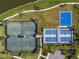 Aerial view showcasing tennis, pickleball, and basketball courts with manicured landscaping at 8271 Redonda Loop, Lakewood Ranch, FL 34202