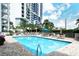 Beautiful community pool and lounging area with surrounding palm trees and nearby condominium building at 1111 N Gulfstream Ave # 8D, Sarasota, FL 34236