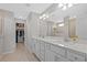 Bright bathroom with double sinks, white cabinetry, walk-in shower, and a spacious walk-in closet at 11419 Gallatin Trl, Parrish, FL 34219