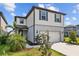 Well-maintained two-story home with a manicured lawn, palm trees, and a two-car garage at 11419 Gallatin Trl, Parrish, FL 34219