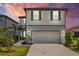 Attractive two-story home with a two-car garage, nice lawn, and decorative blue shutters at dusk at 11419 Gallatin Trl, Parrish, FL 34219