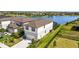 Two-story home showcasing a well-maintained lawn and landscaping, an attached two-car garage, and a glimpse of the lake at 11419 Gallatin Trl, Parrish, FL 34219
