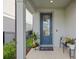 Inviting blue front door with glass insert, plants, and welcome mat at 11419 Gallatin Trl, Parrish, FL 34219