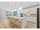 Modern kitchen with white cabinetry, a center island, and dining area nearby at 11419 Gallatin Trl, Parrish, FL 34219