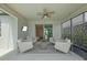 Relaxing covered patio area complete with cozy seating, a ceiling fan, and a mounted television for outdoor entertainment at 11419 Gallatin Trl, Parrish, FL 34219