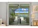 A view through sliding glass doors shows a screened-in patio with view of a pool and scenic lake at 11419 Gallatin Trl, Parrish, FL 34219