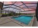 Sparkling screened pool with spa and poolside seating with lake views create a relaxing backyard oasis at 11419 Gallatin Trl, Parrish, FL 34219