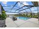 Sparkling pool with screened enclosure, adjacent spa, and comfortable lounge seating overlooking a serene lake at 11419 Gallatin Trl, Parrish, FL 34219