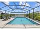 Resort-style screened pool and spa area with lounge chairs and lush landscaping for ultimate relaxation at 11419 Gallatin Trl, Parrish, FL 34219