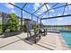 Relaxing screened pool patio with comfortable seating, lush greenery, and a tranquil view of the lake at 11419 Gallatin Trl, Parrish, FL 34219