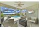 Inviting covered outdoor living space featuring a fire pit, a TV, and a view of the pool and lake at 11419 Gallatin Trl, Parrish, FL 34219