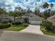 Charming single-Gathering home boasts a well-manicured lawn, mature trees, and a two-car garage, complete with a welcoming front door at 11734 Winding Woods Way, Lakewood Ranch, FL 34202