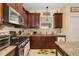 Charming kitchen featuring granite counters, wood cabinets, and stainless steel appliances at 12019 Sawgrass Lake Ter, Bradenton, FL 34211