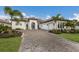 Beautiful one-story home featuring a paver driveway, well-manicured lawn and tropical landscaping at 14803 Derna Ter, Bradenton, FL 34211