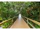 Wood boardwalk trail leads through lush green trees and foliage, offering a peaceful walking path at 1620 Fairway Trce # B, Palmetto, FL 34221