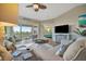 Cozy living room featuring a large sectional, entertainment center, and access to the screened lanai at 1620 Fairway Trce # B, Palmetto, FL 34221