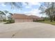 Long driveway leading to a home with a four-car garage and tile roof at 20010 71St E Ave, Bradenton, FL 34211