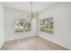 Bright dining room featuring wood floors, large windows with blinds, and an elegant chandelier fixture at 208 Cape Harbour Loop # 108, Bradenton, FL 34212