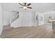 Bright living room with vinyl flooring, a modern ceiling fan, stairs, and an open view to the kitchen at 208 Cape Harbour Loop # 108, Bradenton, FL 34212