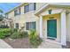 Charming townhouse featuring a vibrant green front door, well-maintained landscaping, and a welcoming entrance at 208 Cape Harbour Loop # 108, Bradenton, FL 34212